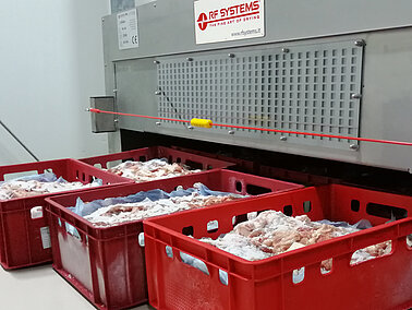 Image qui présente un système de décongélation par radiofréquence avec de grands bacs et de la viande congelée à l'interieur Image qui présente un système de décongélation par radiofréquence avec de grands bacs et de la viande congelée à l'interieur