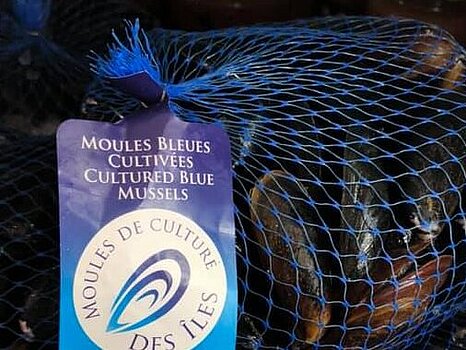 Filet de moules fermé par des clips métalliques, avec une étiquette indiquant le produit ou la marque