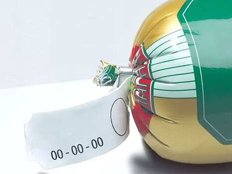 Photo d’une saucisse munie de clips métalliques à chaque extrémité, avec une étiquette fixée d’un côté, sur un fond simple